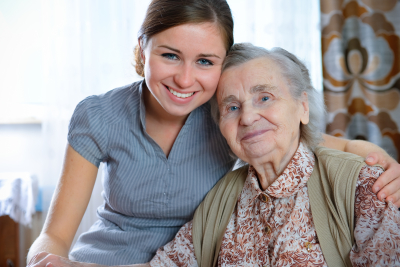 caregiver and senior woman are smiling